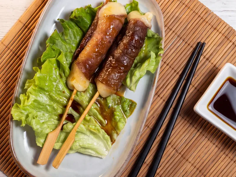 Photo de deux brochettes bœuf fromage sur salade, baguettes et sauce soja chez Yushithaï, le meilleur restaurant japonais halal à Lyon 6, Masséna, près de la Part-Dieu