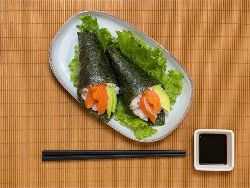 Photo de deux temakis saumon avocat roulés à la main sur une assiette avec salade chez Yushithaï, le meilleur restaurant japonais à Lyon 6, Masséna, près du métro Brotteaux