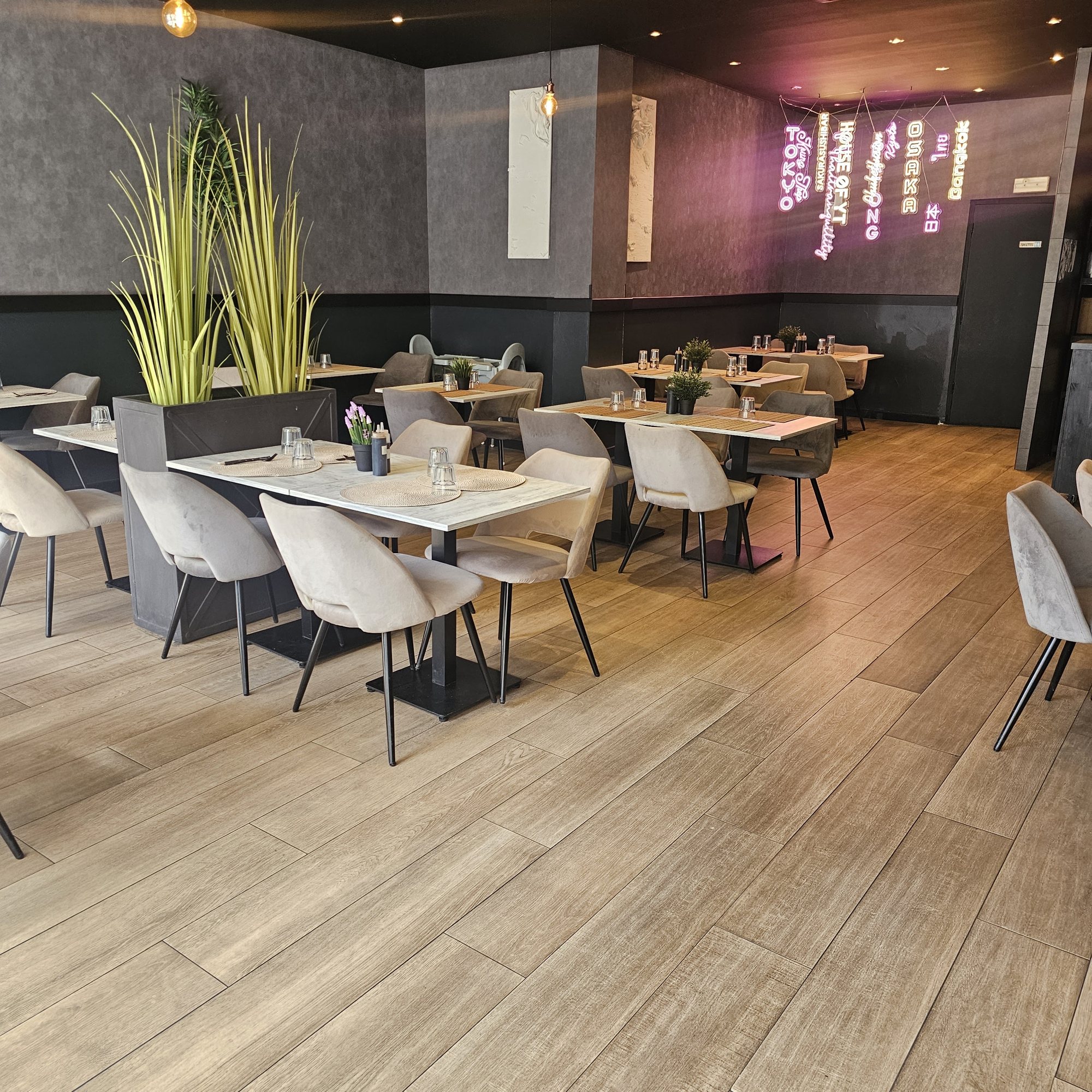 La salle de Yushithaï, ses tables en marbre alignées et l'enseigne au néon au fond
